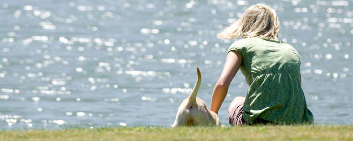 Mädchen mit Hund am Wasser